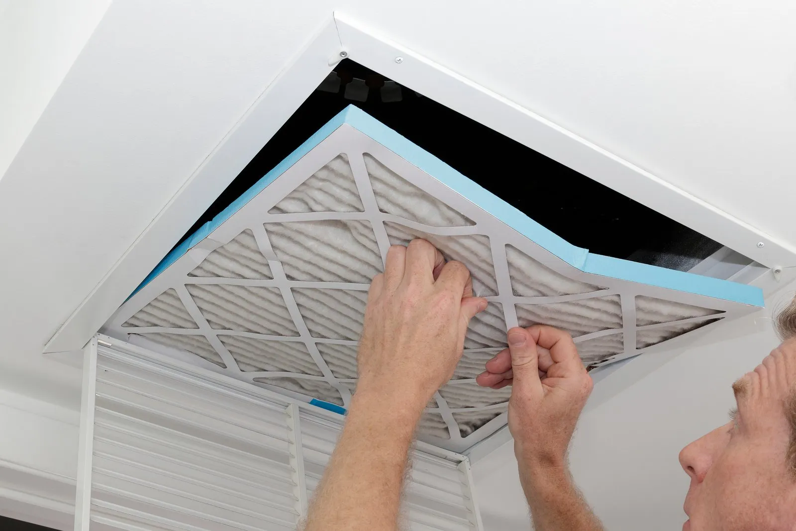 Technician cleaning an air duct vent in a Maple Valley home